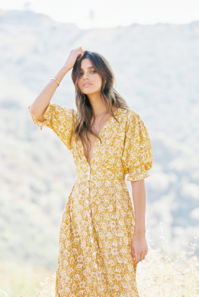 Woman in white dress standing in a field with a blurry background