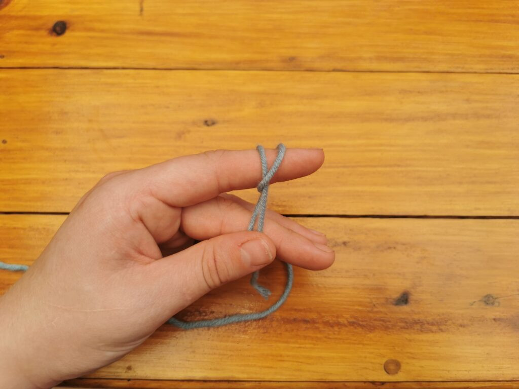 Ensuring the loop remains on the finger prevents the knot from tightening prematurely