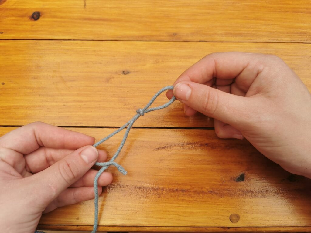 Tightening the knot around the hook readies the yarn for creating the first chain stitch