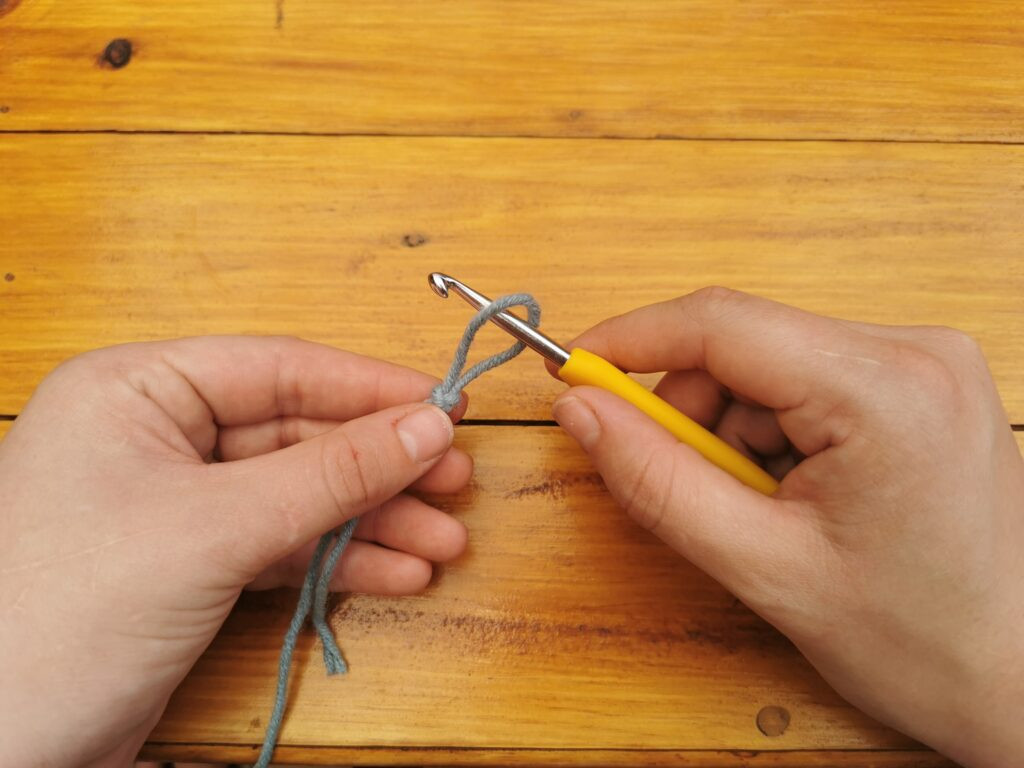 Inserting the hook into the loop ensures the slip knot is correctly positioned to begin crocheting