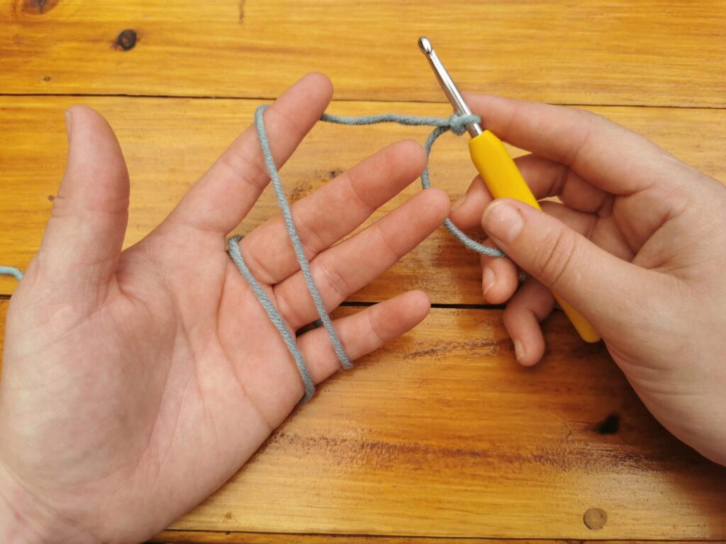 Guiding the yarn from back to front around the index finger supports a smooth yarn flow