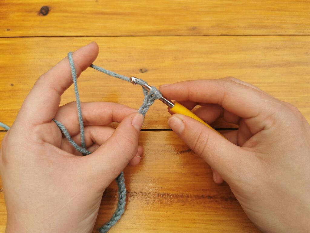 Yarning over once more prepares to draw the yarn through both loops, finishing the stitch