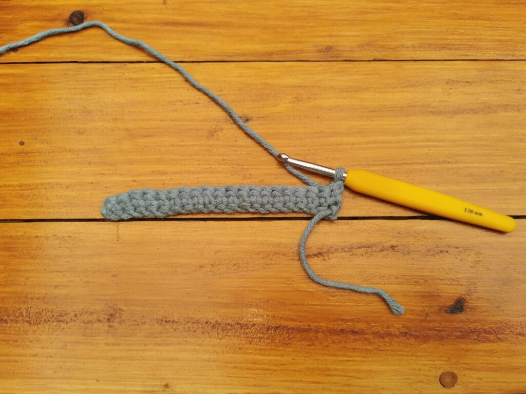 Turning the work ensures consistent stitch direction and a neat fabric appearance