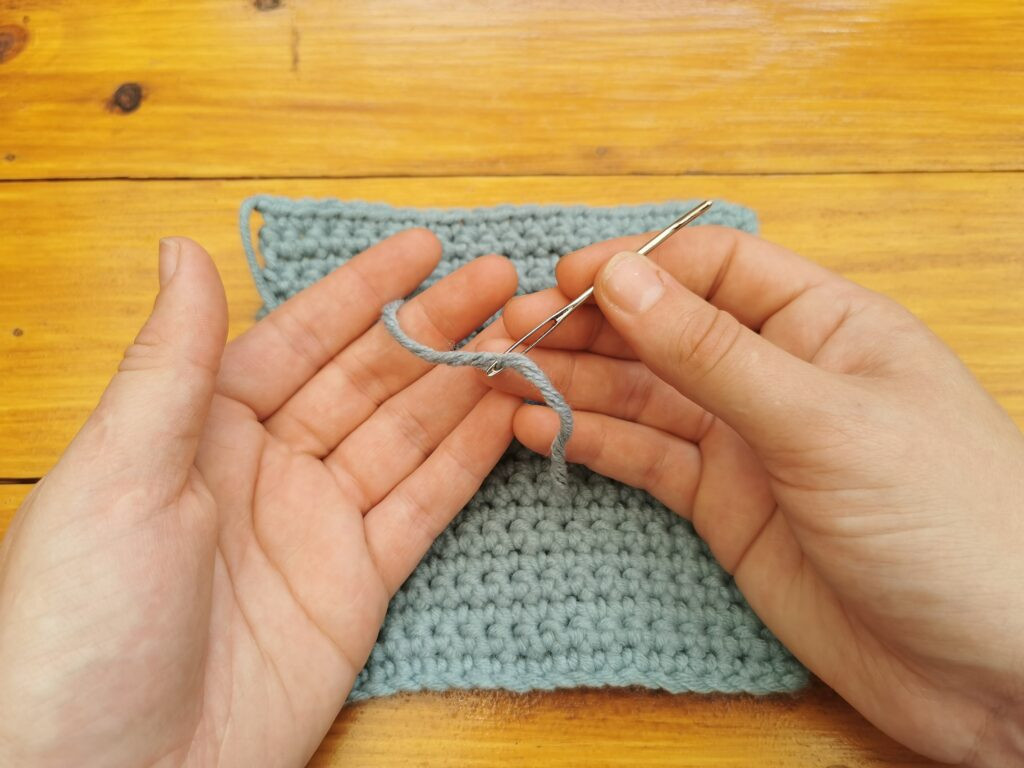 Pull the yarn through the eye of the needle