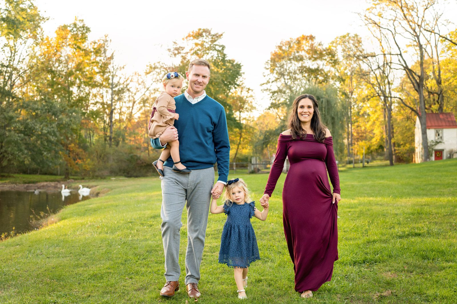 Expecting parents walking with daughters, captured at 28 weeks