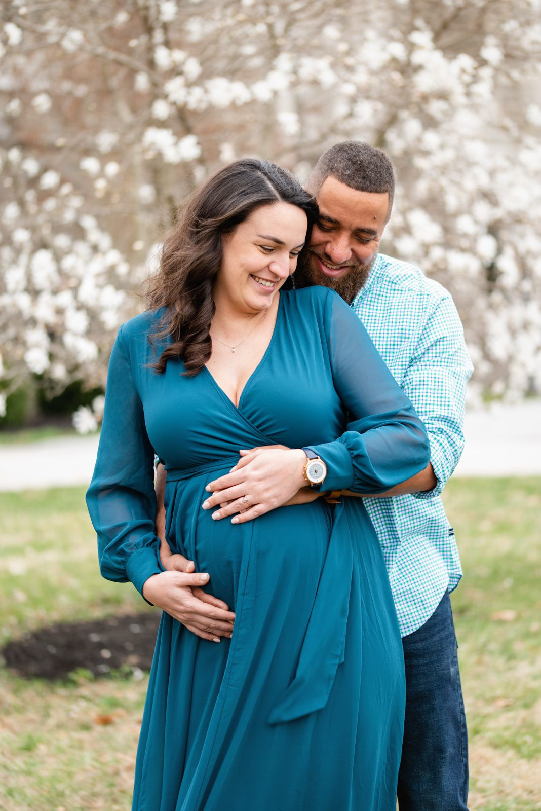 Expecting couple with white flowers, captured at 33 weeks