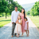 Family in coordinated outfits standing in a field, showcasing how to dress for family photos using a cohesive color palette