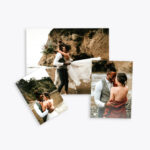 Three printed wedding photographs are arranged on a white surface, featuring a couple embracing on a beach with cliffs in the background.
