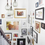 Eclectic family photo gallery wall using a mix of frames, sizes, and styles on a stairwell.