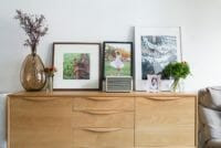 A dresser showcasing photos on top, illustrating how to incorporate personal photographs into home décor
