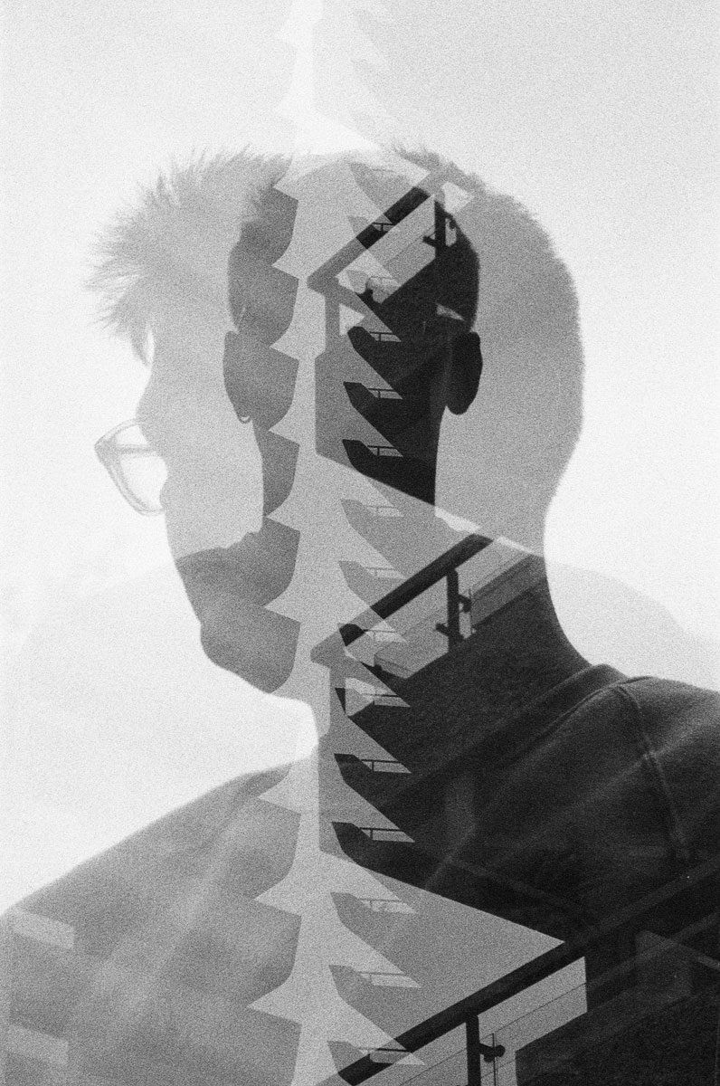 Black and white double exposure portrait with stairs in the middle.