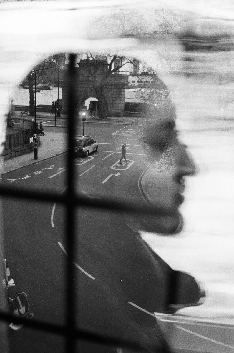 Black and white double exposure portrait with a road going through the middle.