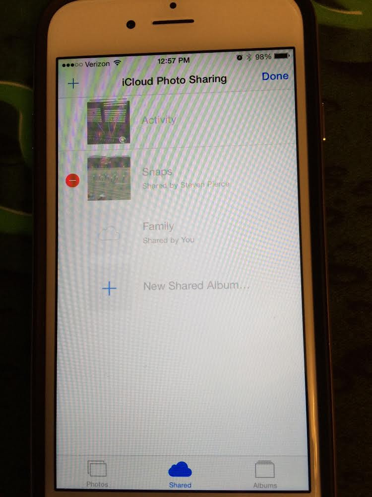 iPhone screen displaying the Shared Albums section in the Photos app, with an album selected and the delete option highlighted, illustrating how to delete a shared album