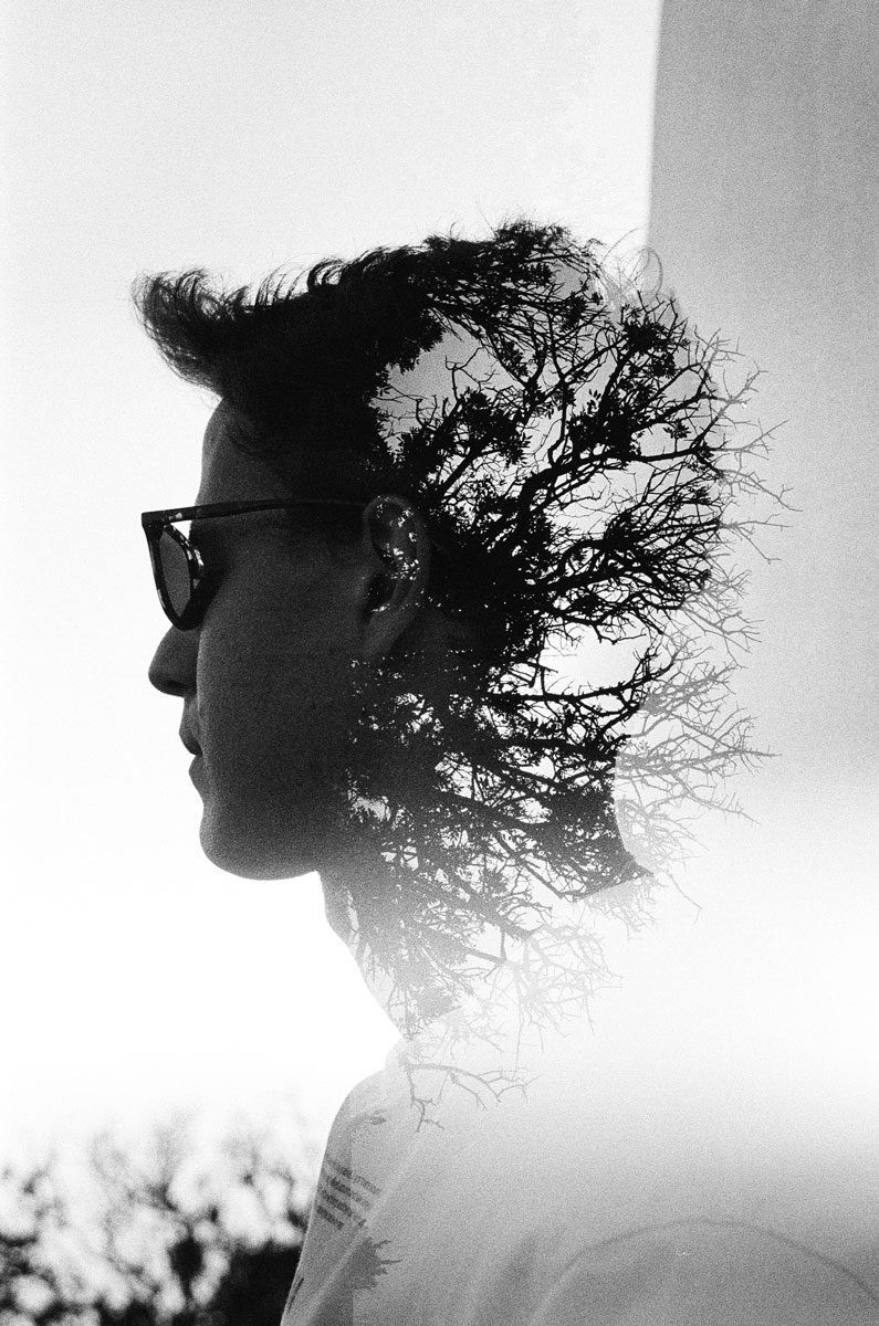 Black and white double exposure portrait with branches for hair