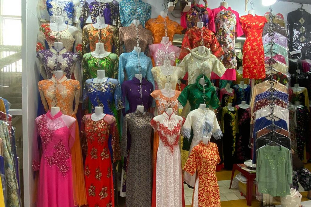 A vendor displaying colorful fabrics at An Dong Market