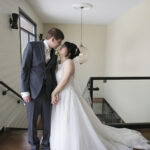 Elegant couple posing on A'Bulae's grand staircase, captured in a sweeping wedding photo showcasing the venue's architecture and natural light.