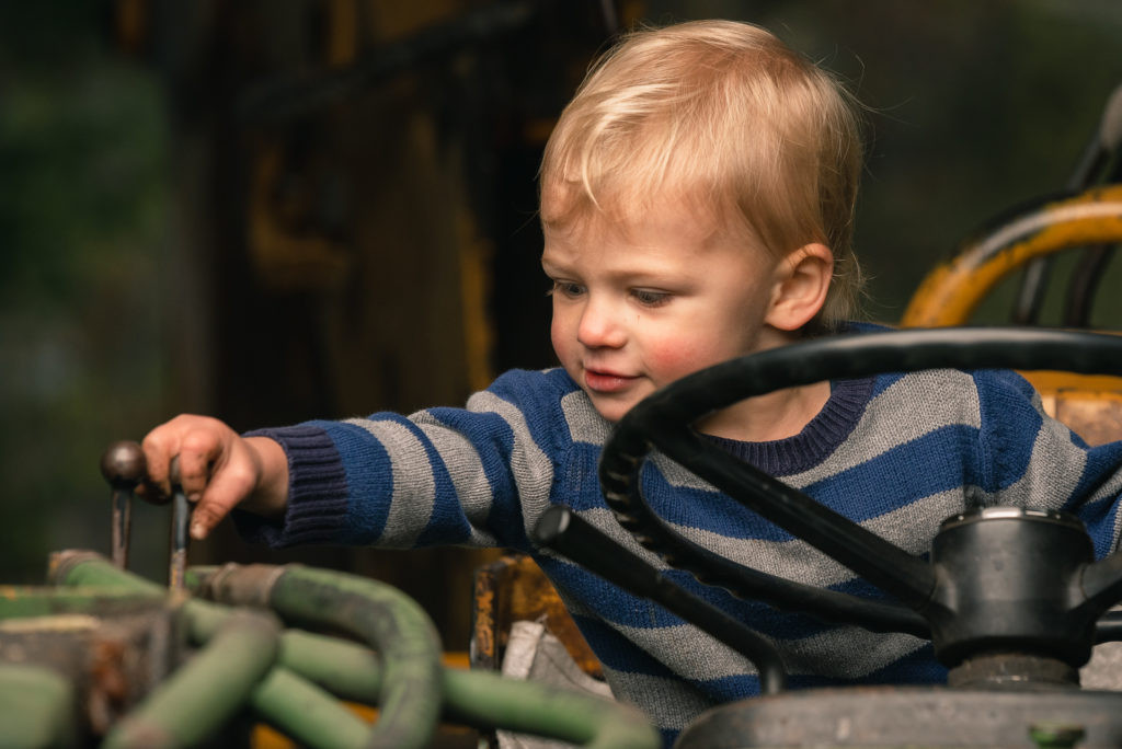 A young boy sitting on a tractor.