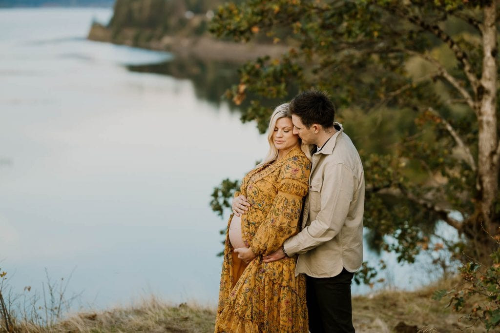 Mom in a free people maxi dress, showcasing a flowing, patterned fabric that complements the natural setting. The dress's pattern adds visual interest without overwhelming the subject, making it ideal for maternity photography.