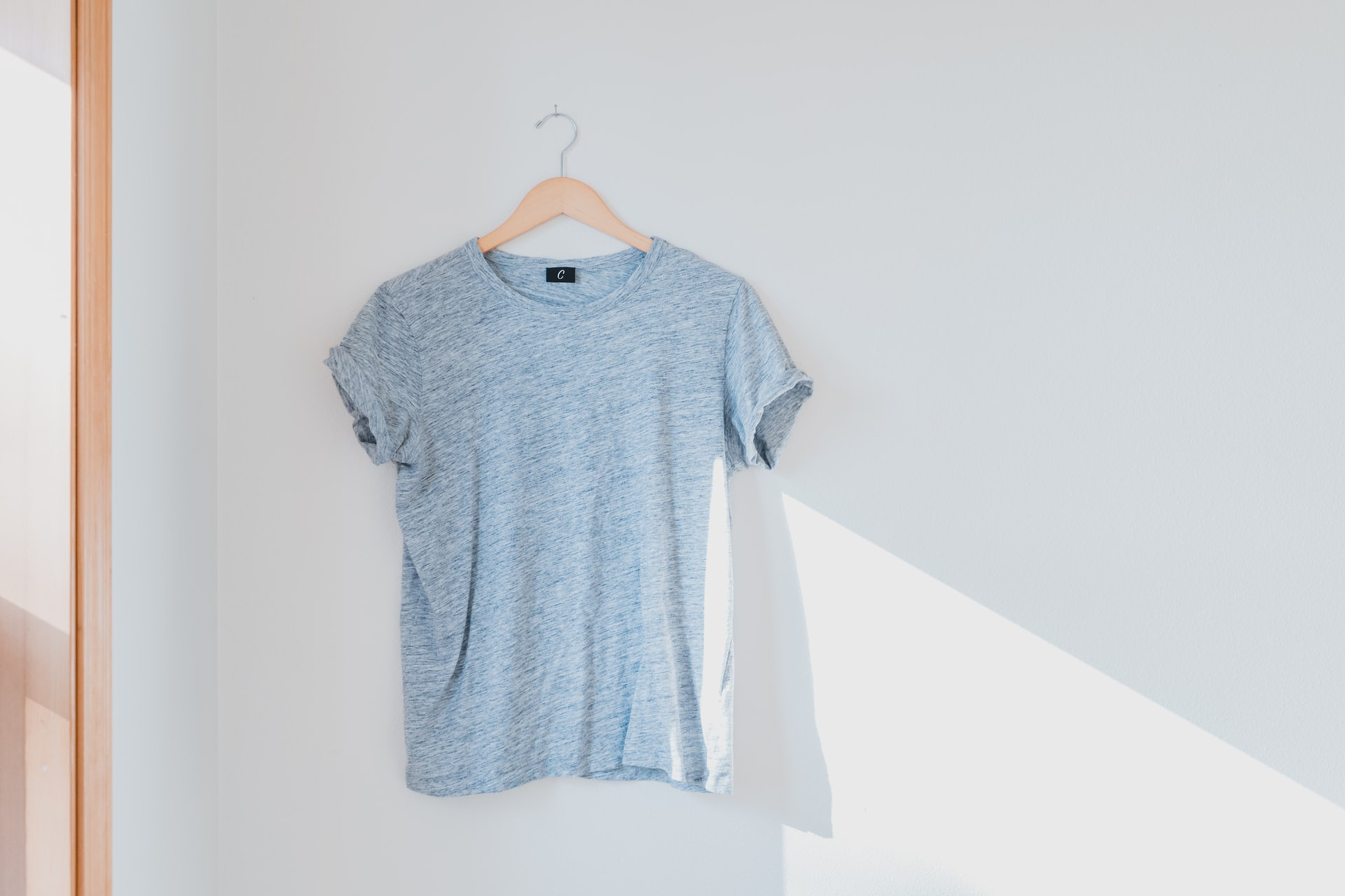 T-shirt hanging on a white wall showcases garment simplicity and design