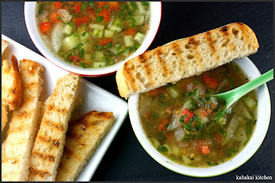 A bowl of gazpacho with fresh herbs, showcasing the vibrant colors and textures of the dish.