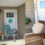 Wide angle shot of delivery package on doorstep with house number visible