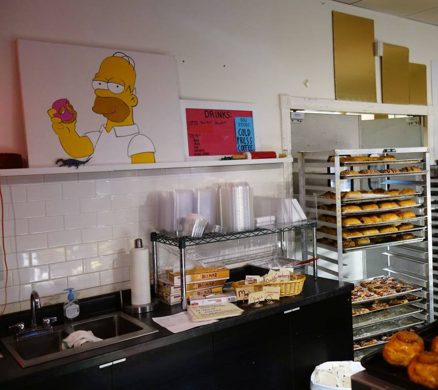 A customer selecting pastries at A Baker's Wife's Pastry Shop, highlighting the shop's appeal and variety