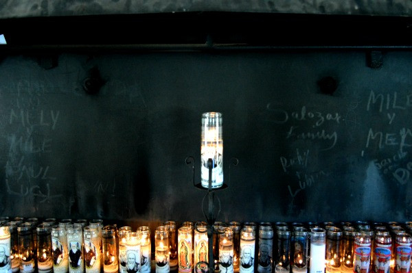 Close-up of offerings left at the shrine, including candles, notes, and personal mementos