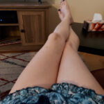 Legs crossed against a wall, showcasing a sensual pose