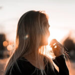 Girl watching the horizon during sunset, demonstrating the potential for glare