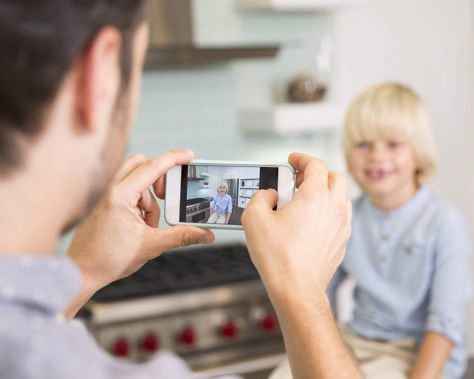 Father taking photo of child at home with good lighting and neutral expression