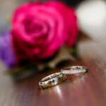 Wedding couple smiling at each other with their wedding bands shining