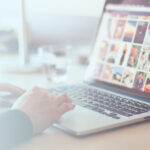 Close-up of a hand attaching a photo to an email on a laptop, emphasizing user interaction and technology use.