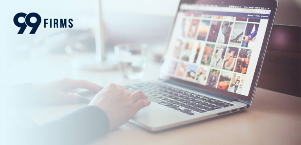 Close-up of a hand attaching a photo to an email on a laptop, emphasizing user interaction and technology use.