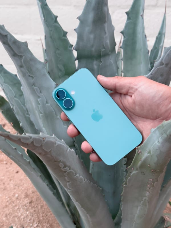Rear view of iPhone 16 non-Pro in ultramarine, emphasizing the vertically stacked camera design and aesthetic appeal.