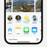 iPhone showing the share sheet with photos selected and the AirDrop option displayed, illustrating how to send photos from iPad to iPhone.