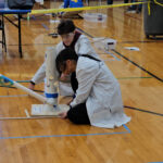 Students making an air trajectory device, captured in a photo that highlights their collaborative effort and innovative approach