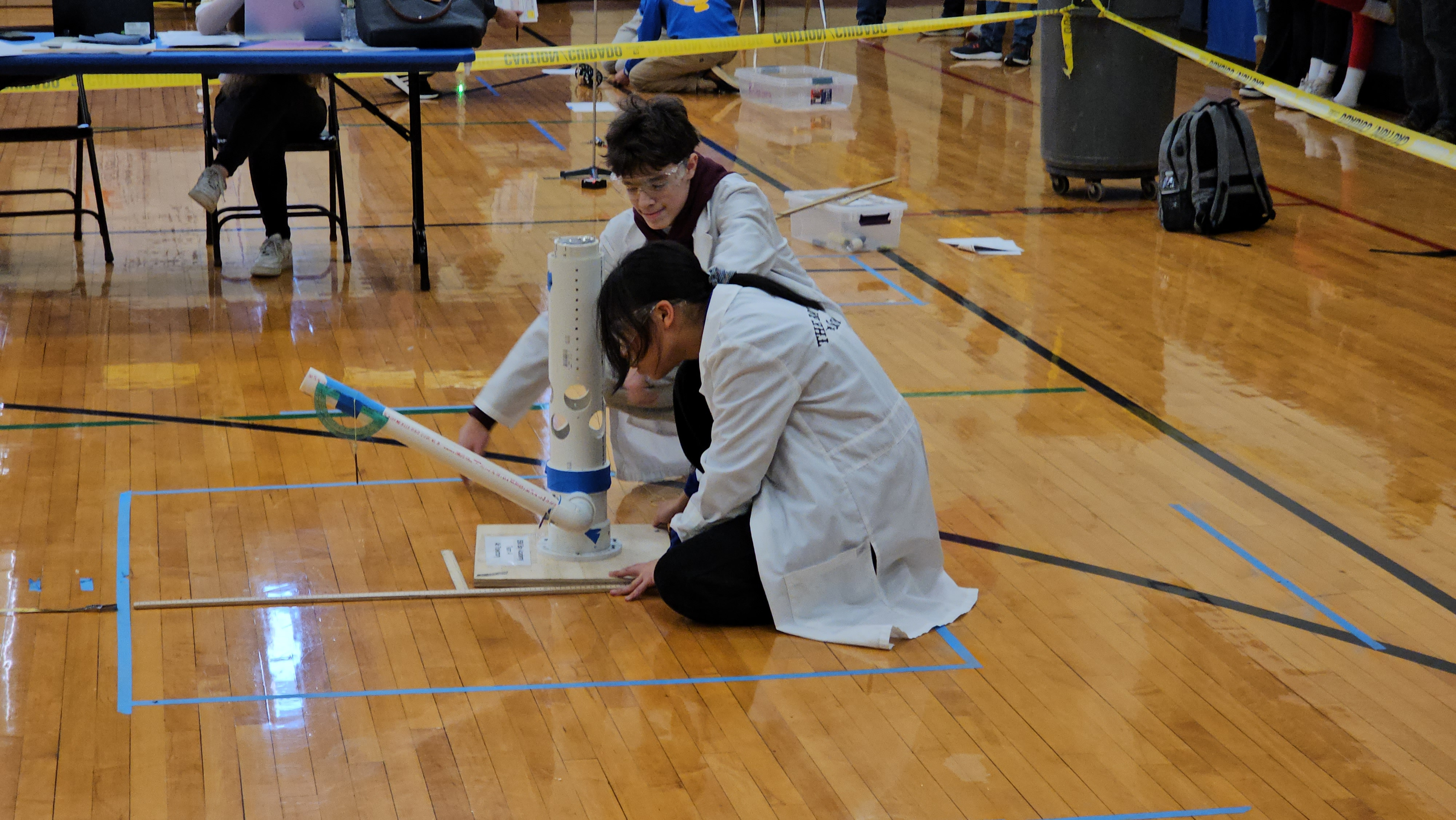 Students making an air trajectory device, captured in a photo that highlights their collaborative effort and innovative approach