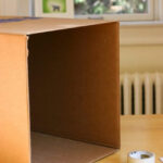 Cardboard box with cut openings for lightbox creation, ensuring neat edges and structural integrity