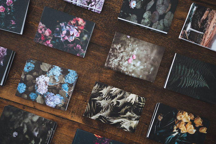 Flat lay of lustre &amp; glossy nature photo prints neatly stacked and arranged on a table