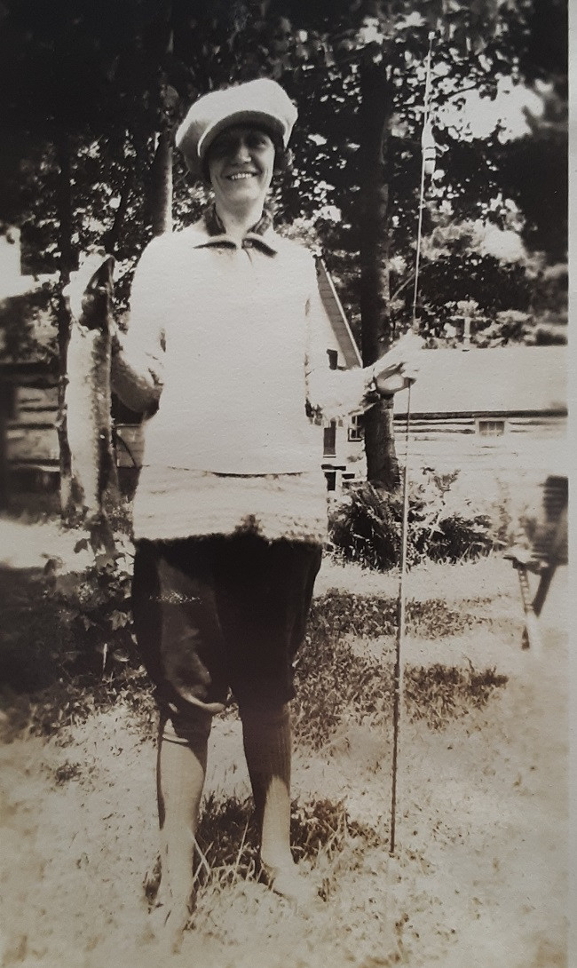 Women in 1920s attire pose with fishing catch, embodying the era's leisure activities