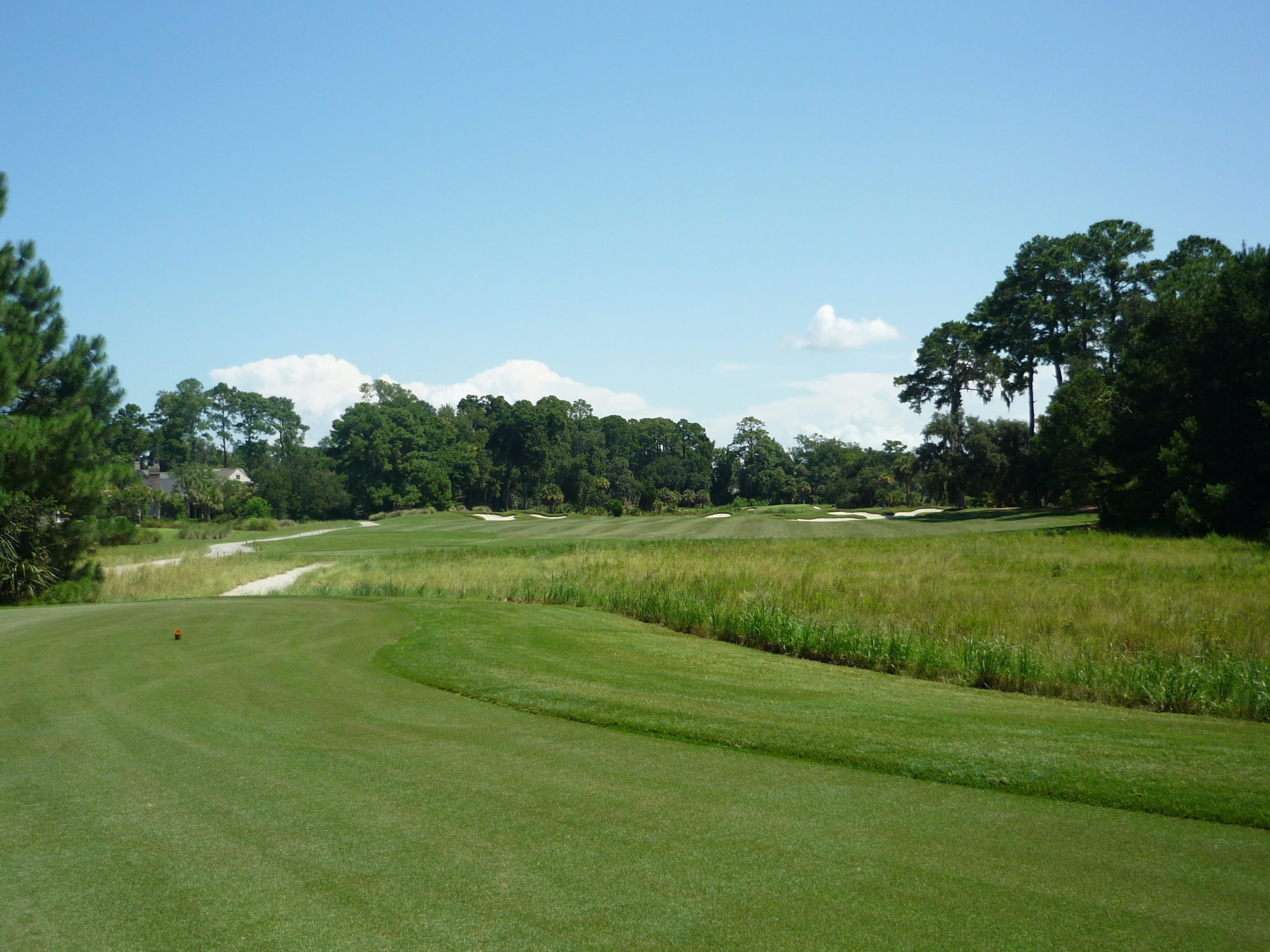 A scenic view of May River Golf Club under a sunny sky with scattered clouds