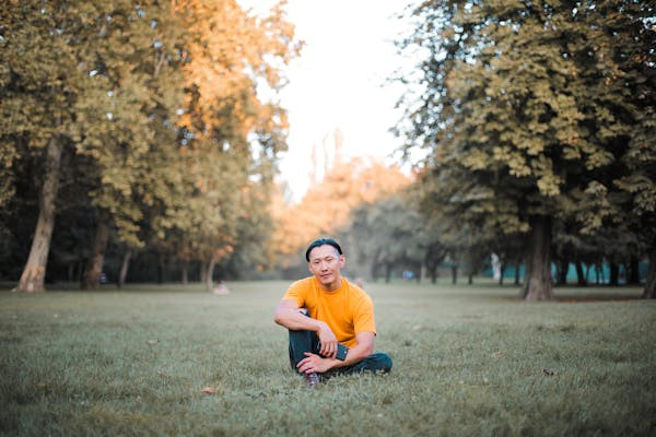 A photographer focusing the lens of a professional camera during an outdoor photoshoot, highlighting the practical application of photography skills.