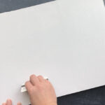 Hand using credit card to smooth photo down