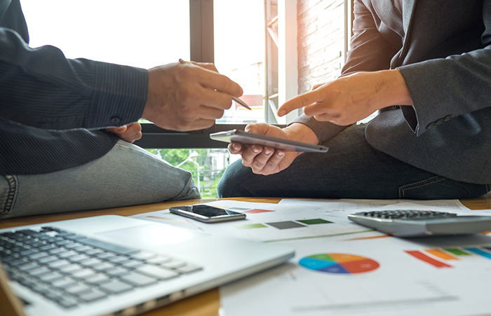 Two men consulting about finances, representing a business meeting where photography pricing and financial strategies are discussed