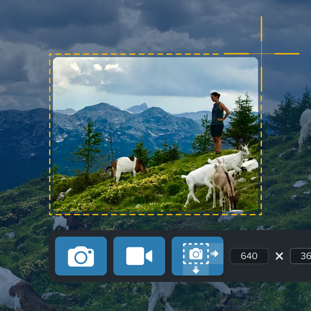 Someone using Snagit to take a screenshot of a mountain scene with cropping tools visible.