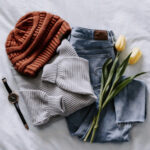Flatlay disposition of clothes showcases various clothing items arranged on a clean backdrop