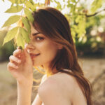 Woman smiling and holding leaves in nature