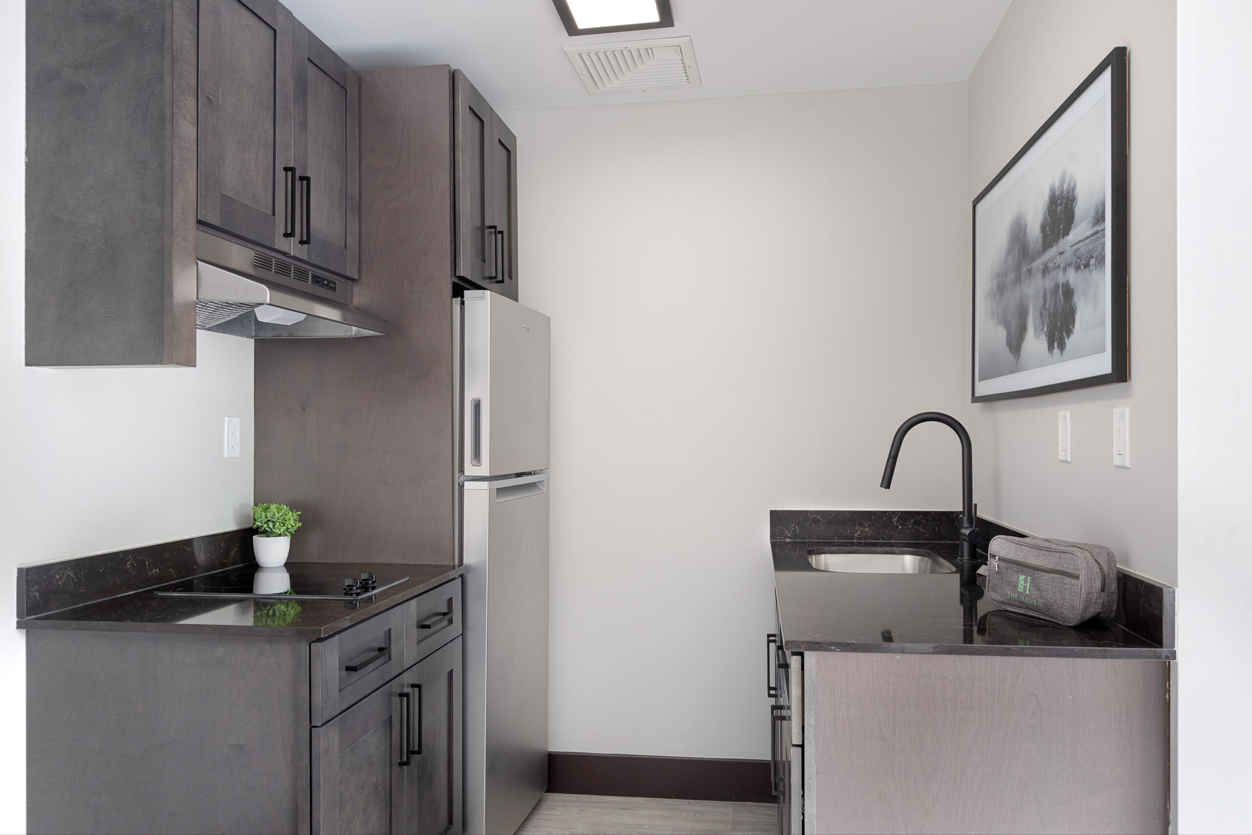 A modern kitchenette inside The Haven at Westwood, equipped with essential appliances and stylish design