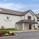 Exterior view of The Haven at Westwood featuring well-maintained landscaping and ample parking, showcasing the hotel's welcoming ambiance