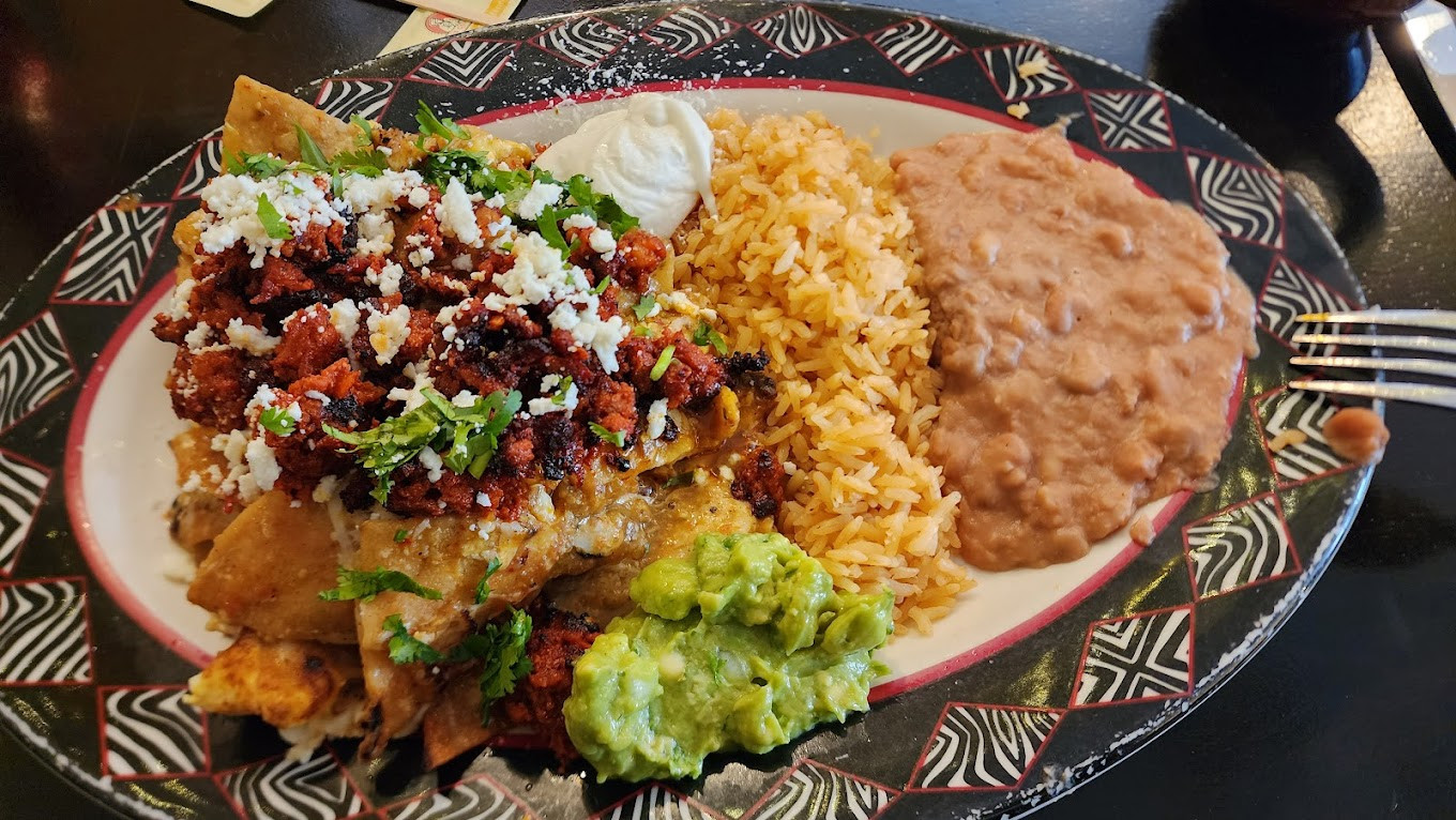 Chilaquiles verdes (green) de chorizo served with beans and rice.